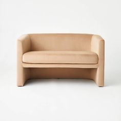 a beige couch sitting on top of a white floor