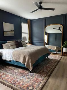 a bedroom with dark blue walls and wooden floors