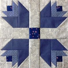 a blue and white quilted block with an arrow design on it's side