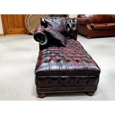 a brown leather chaise lounger sitting on top of a white carpeted floor