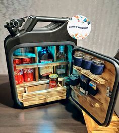 an open refrigerator with drinks and condiments in it on top of a wooden table