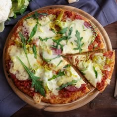 a pizza sitting on top of a wooden cutting board next to a knife and fork