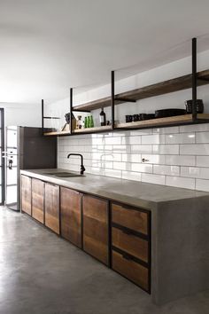 an industrial style kitchen with wooden cabinets and shelving