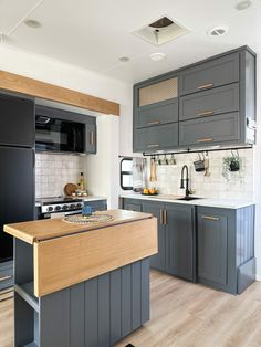 a kitchen with gray cabinets and wooden counter tops