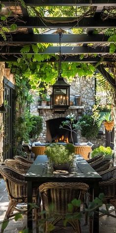 an outdoor dining area with wicker chairs, table and fire place in the background