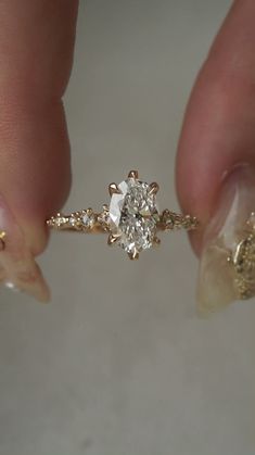 a person holding a diamond ring in their hand