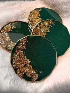 four green and gold leaf shaped plates sitting on a white furnishing area with golden flecks