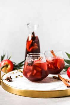 two glasses filled with apple cider on a tray