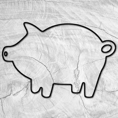 a black and white photo of a pig cut out of paper on a piece of wood