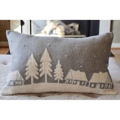 a gray pillow with trees and houses on it