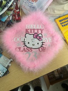 a pink hello kitty plush toy sitting on top of a table