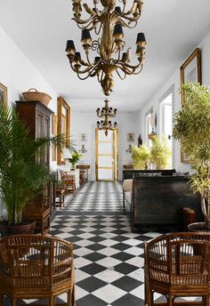 a room filled with lots of furniture and a chandelier hanging from the ceiling