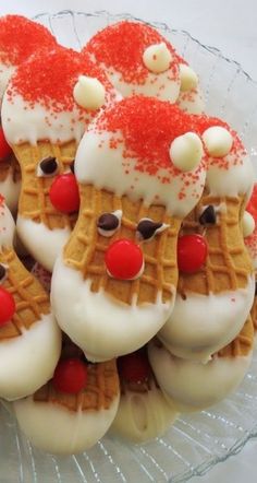 some christmas themed waffles are on a glass plate with white frosting and red sprinkles