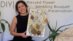 a woman holding up a painting in front of a sign that says, pressed flower wedding bouquet presentation