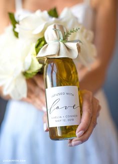 a bride holding a bottle of wine with flowers in it and the label says, i'm married with love