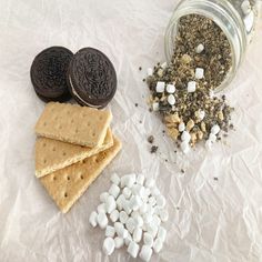 cookies, marshmallows and oreos are sitting on the table next to each other