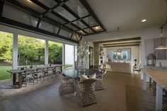 a large open living room and dining area with glass doors leading to an outside patio