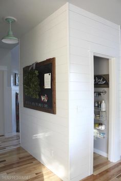 an empty room with white painted walls and wood flooring is seen in this image