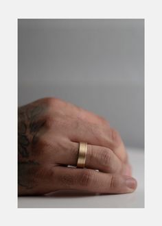 a man's hand with a gold ring on it