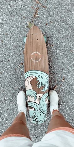 a person standing next to a skateboard with waves on it's bottom half