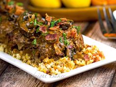 a white plate topped with meat and rice