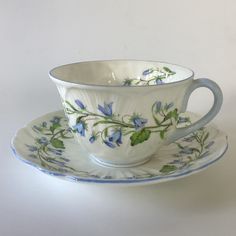 a cup and saucer decorated with blue flowers