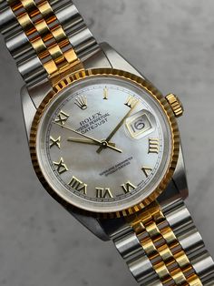 Lanzado en 1945, el Datejust es la colección más antigua de Rolex y se creó para conmemorar el 40.º aniversario de la empresa. A diferencia de otros relojes Rolex, el Datejust no fue diseñado para una actividad o entorno específico y simplemente existe como un reloj inteligente y confiable. Pionero en su época, el Datejust fue el primer reloj automático en presentar una ventana de visualización de fecha y también el primer reloj Rolex en usar el diseño de pulsera Jubilee. Combinado con el estuch Watch Review, Rolex Watch, Bracelet Design, Telling Time, Functional Accessories, Tried And True, 40th Anniversary, Dress Watch, Watch Model