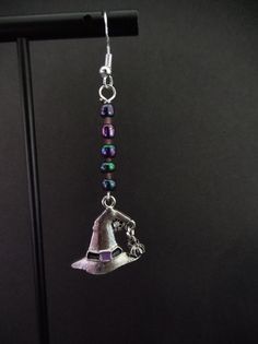 a pair of silver bells with beads hanging from it's earwires on a black background