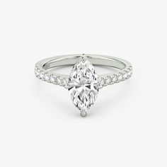 a pear shaped diamond engagement ring on a white background