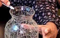 a close up of a person holding a glass vase with string wrapped around the bottom