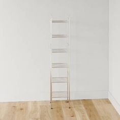 an empty room with a ladder leaning against the wall and wood flooring in front of it