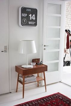 an image of a room with a clock on the wall and a table in front of it