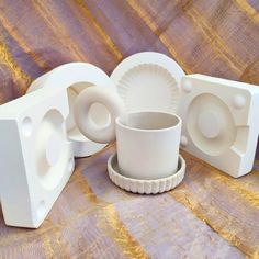 three white plastic objects sitting on top of a wooden table next to each other with holes in the middle