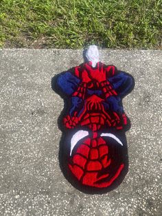 a spiderman stuffed animal laying on the ground