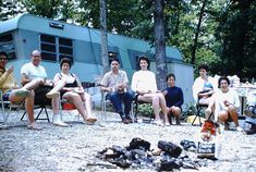 a group of people sitting in chairs next to an rv