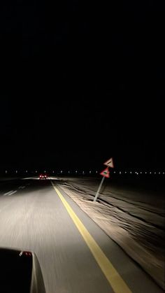 a car driving down the road at night