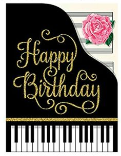 a happy birthday card with a pink flower on top of a black piano and gold lettering