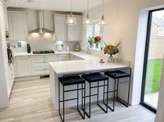 a kitchen with an island and three stools in front of the counter top area