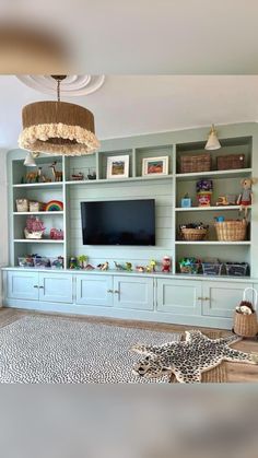 a living room filled with lots of furniture and a flat screen tv mounted on top of a wall