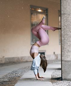 a woman doing a handstand on the sidewalk