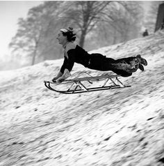 a person riding a sled down a snow covered slope