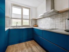 a kitchen with blue cabinets and wooden floors