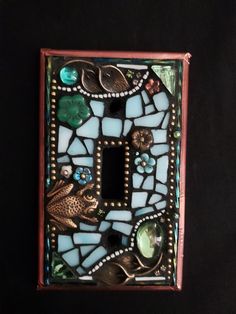 a decorative light switch plate with glass and metal accents