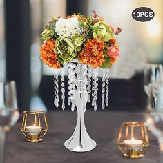 the centerpieces are decorated with flowers, candles and crystal bead chains for an elegant touch