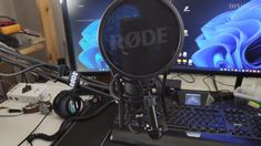 a microphone sitting on top of a desk next to a laptop computer and monitor screen