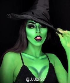 a woman dressed in green and wearing a witches hat