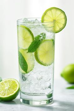 a glass filled with ice and lime slices