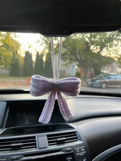 a car dashboard with a bow hanging from the dash board