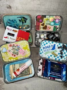 four tins filled with different items on top of a wooden table next to each other