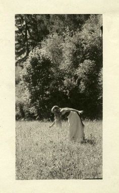 an old black and white photo of two women in a field